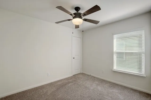 en empty room with window and ceiling fan