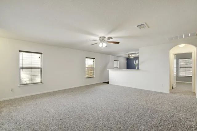 a view of a livingroom with a ceiling fan and window