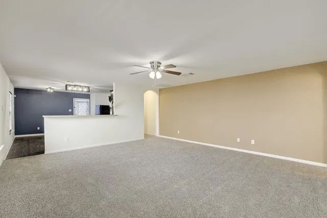 a view of a livingroom with a ceiling fan and window