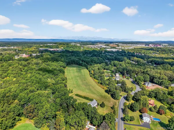 an aerial view of a houses with a yard and lake view