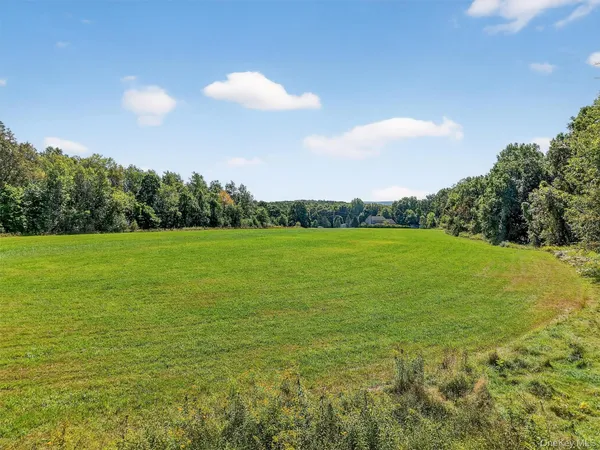 a view of a green field with wooden fence
