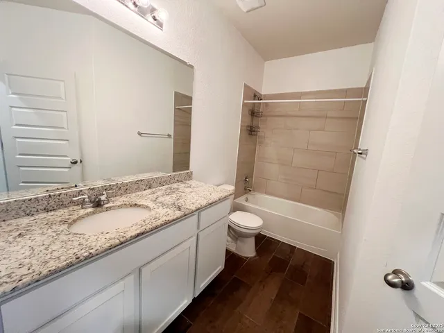 a bathroom with a granite countertop sink toilet and shower