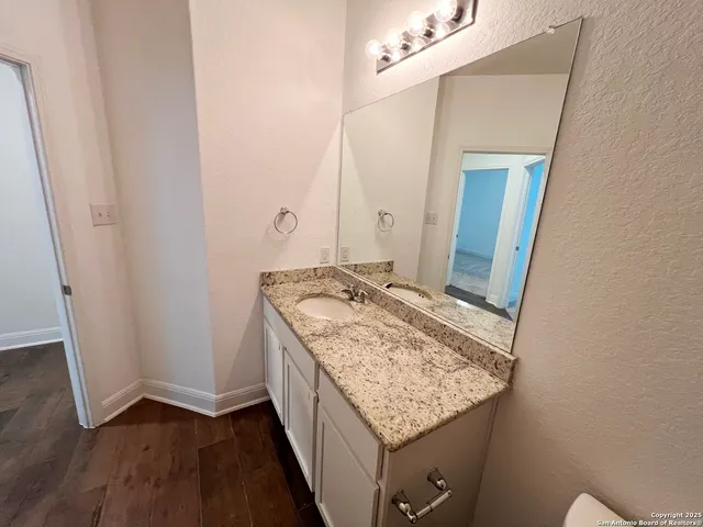 a bathroom with a granite countertop sink and a mirror