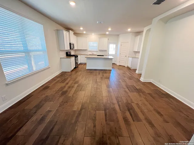 a view of kitchen with wooden floor and electronic appliances