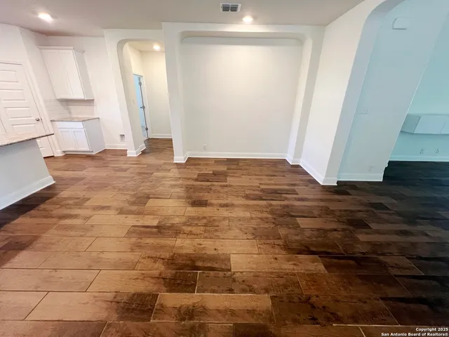 a view of empty room with wooden floor