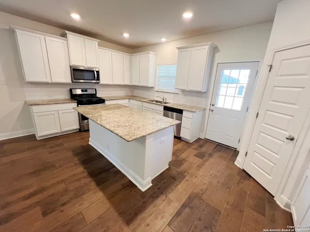 a kitchen with a stove a sink and a refrigerator