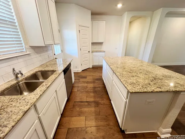 a kitchen with granite countertop sink and cabinets