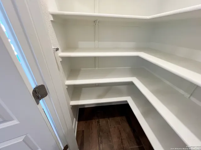 a view of walk in closet with empty racks