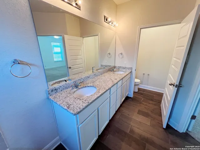 a bathroom with a granite countertop sink and a mirror