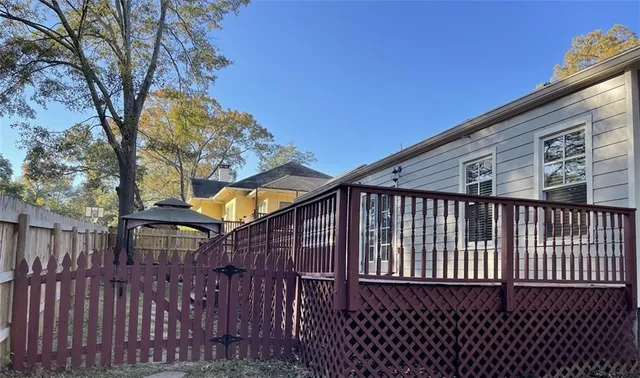 a view of a house with a small yard and wooden fence