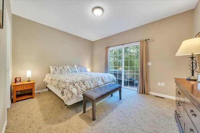 a bedroom with a bed and a lamp next to a window