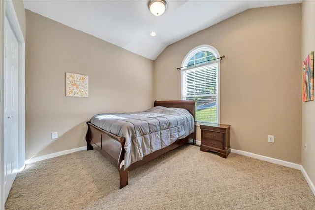 a bedroom with a bed lamp and a window