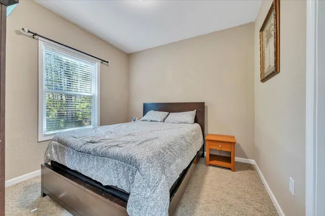 a bed sitting in a bedroom next to a window