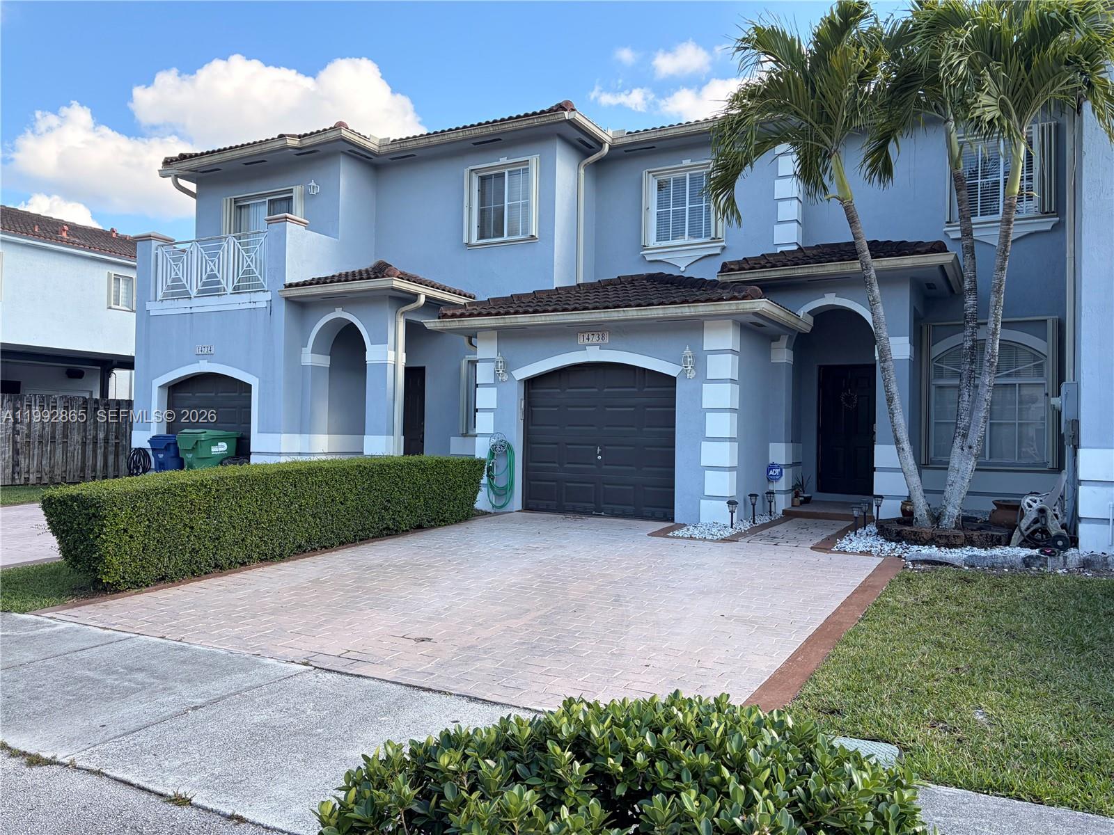 a front view of a house with a garden and plants
