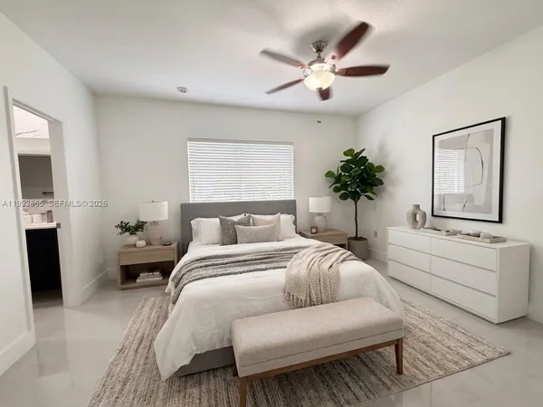 a spacious bedroom with a large bed couch and windows