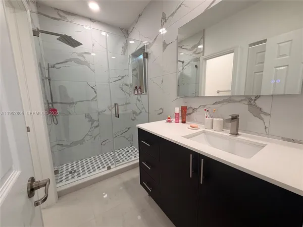 a bathroom with a shower sink and mirror