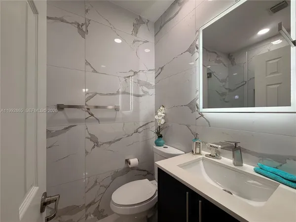 a bathroom with a sink toilet vanity and shower