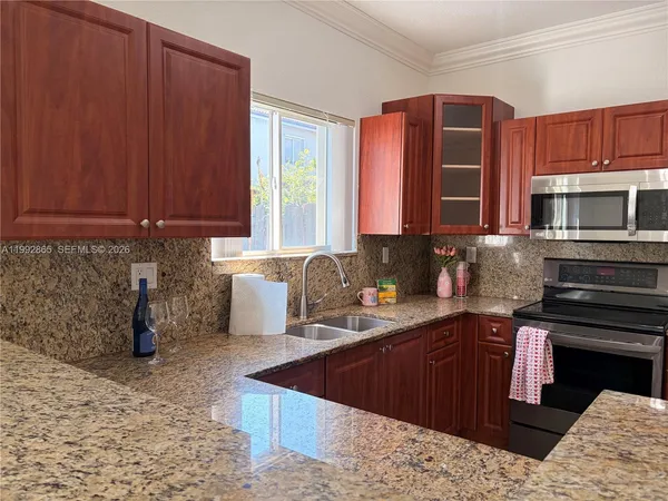 a kitchen with stainless steel appliances granite countertop a sink stove and microwave