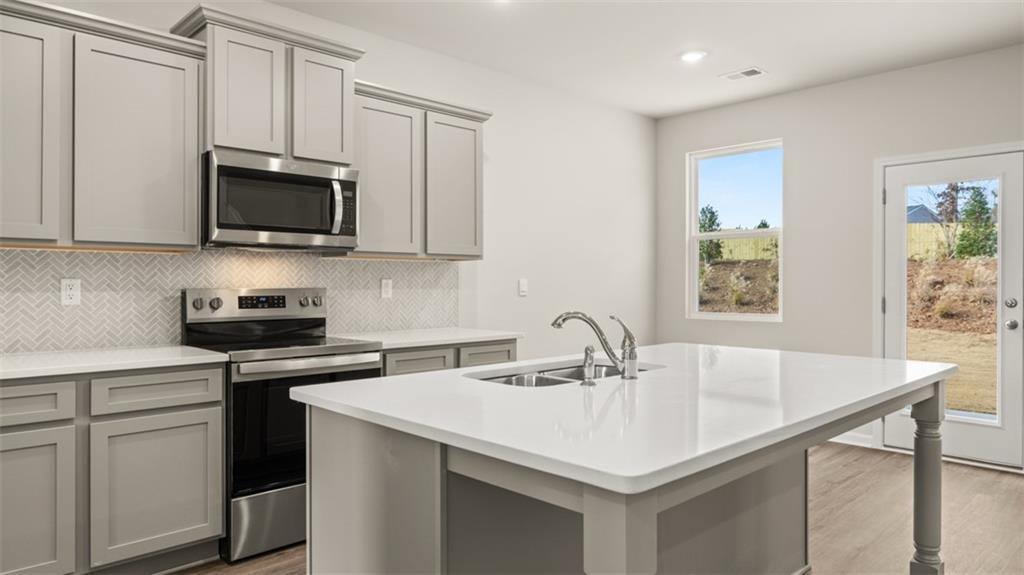112 Holland Cove Winder, GA 30680 - Photo 7 of 26 a kitchen with stainless steel appliances a sink a stove and microwave