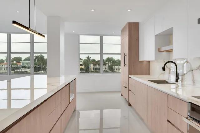 a large white kitchen with a large window