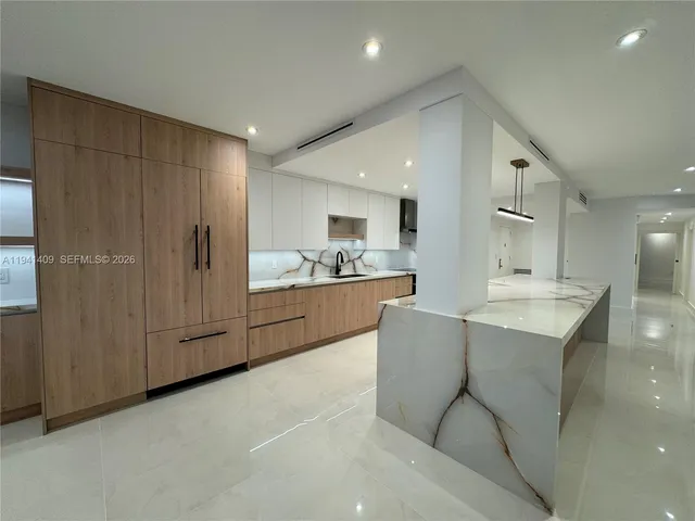 a large kitchen with stainless steel appliances kitchen island a large counter top