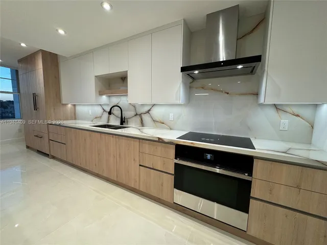 a kitchen with stainless steel appliances granite countertop a sink a stove and a microwave