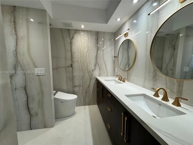 a bathroom with a double vanity sink mirror and toilet