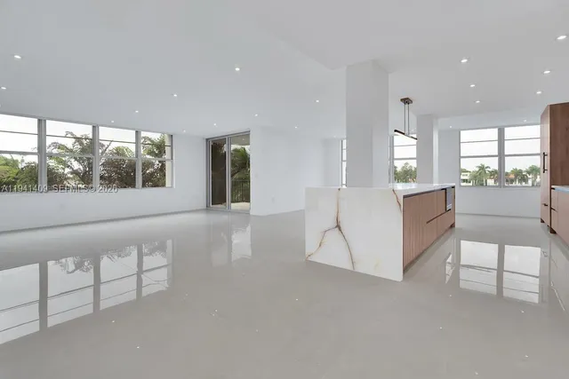 a large white kitchen with granite countertop a large window and a sink
