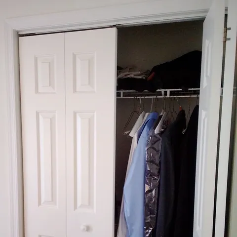 a view of walk in closet with clothes and shoes