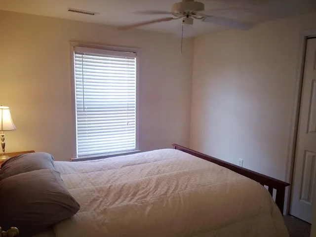 a bed sitting in a bedroom next to a window