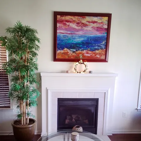 a living room with a potted plant and a fireplace