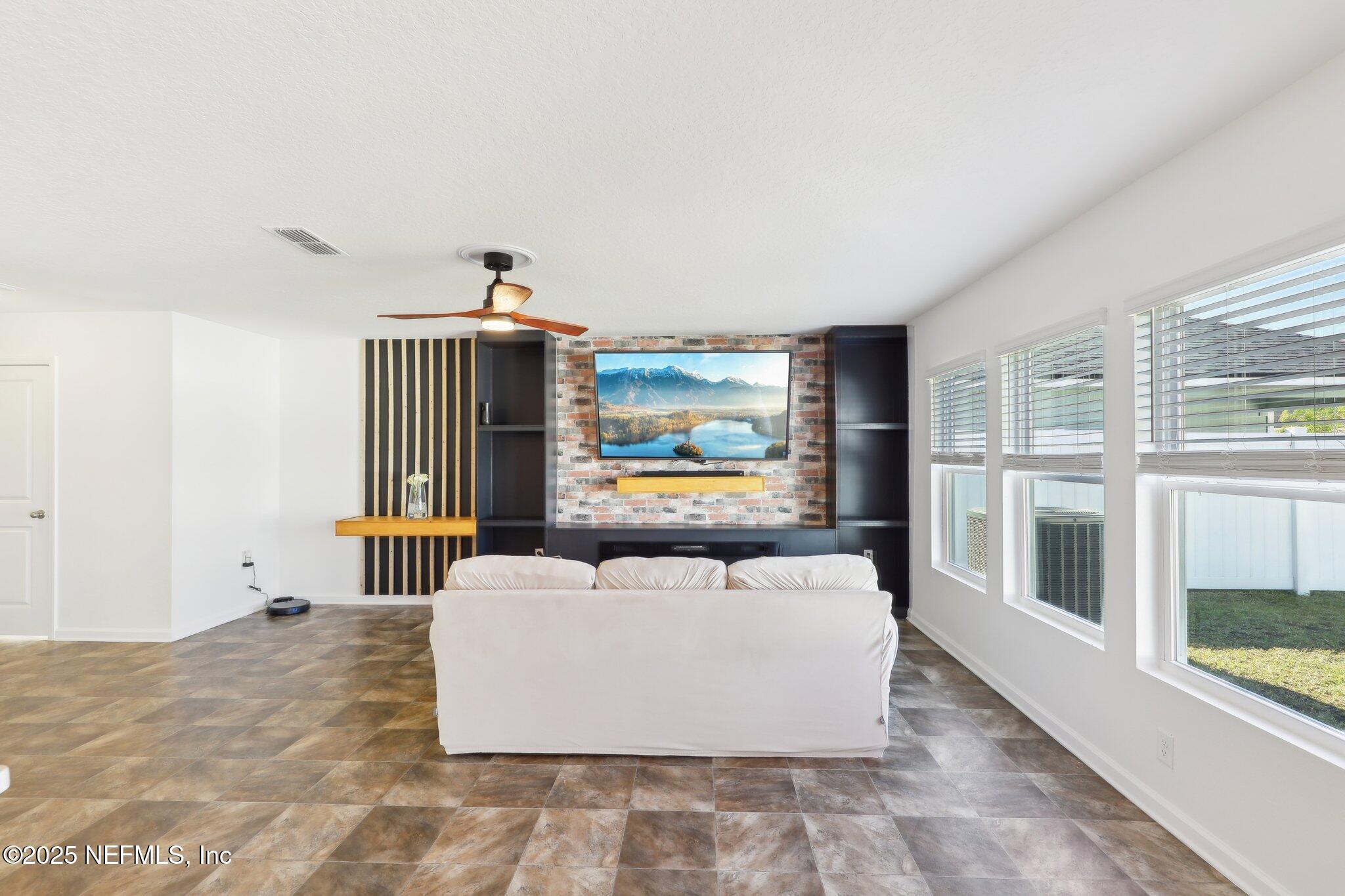 11461 Nathaniel Gorham Way Jacksonville, FL 32221 - Photo 11 of 42 a living room with furniture and a flat screen tv