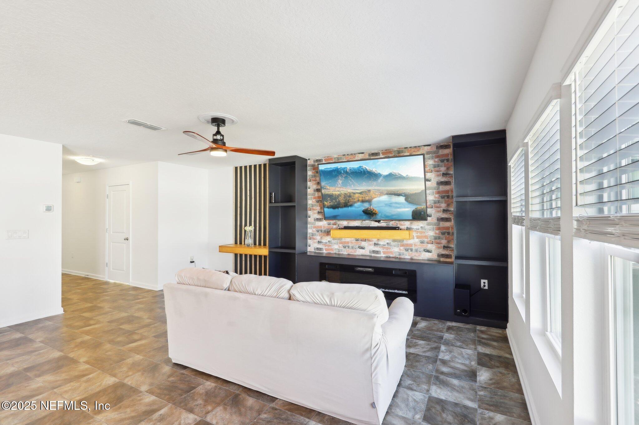 11461 Nathaniel Gorham Way Jacksonville, FL 32221 - Photo 12 of 42 a living room with furniture and a flat screen tv