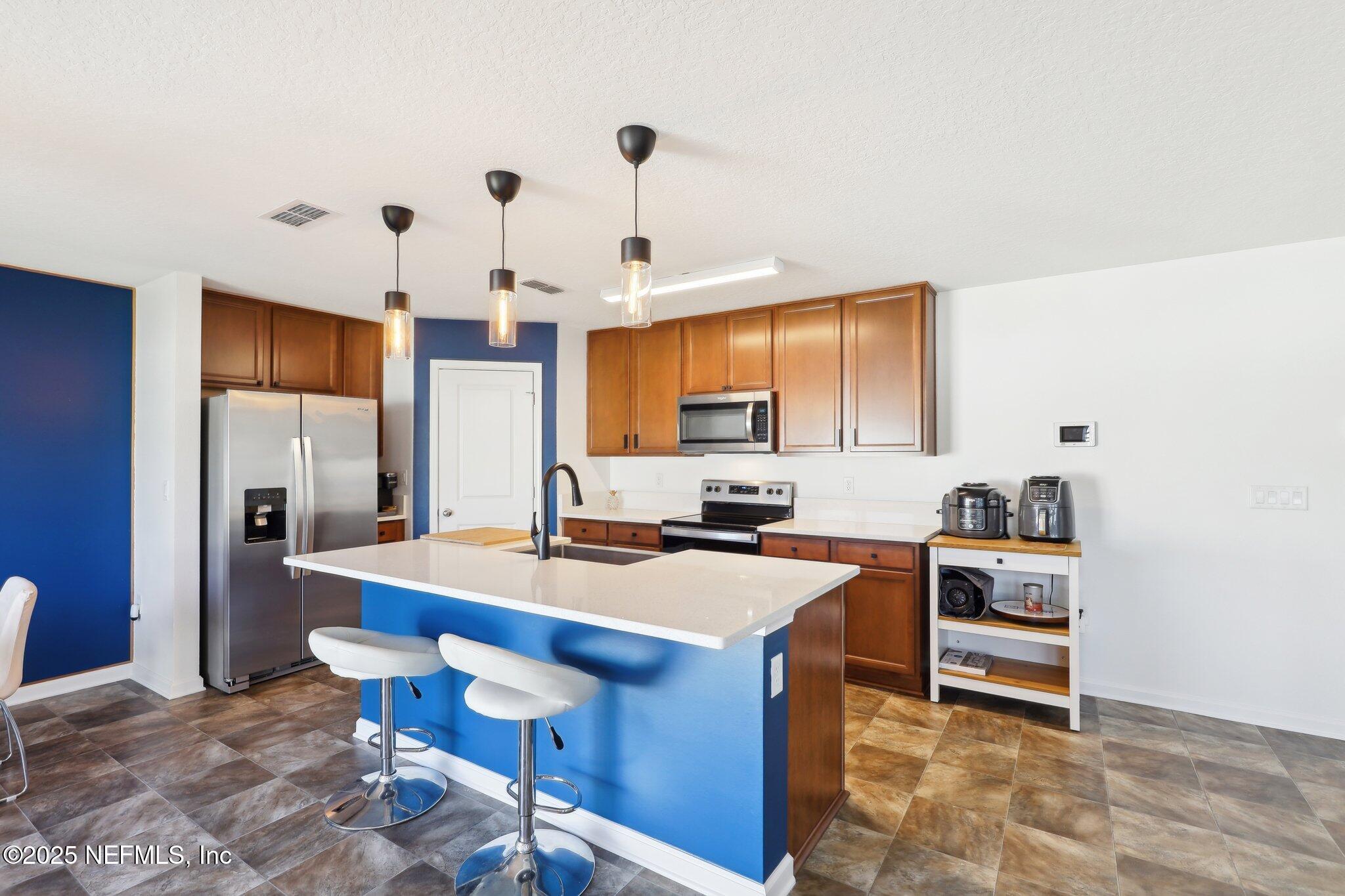 11461 Nathaniel Gorham Way Jacksonville, FL 32221 - Photo 14 of 42 a kitchen with a table chairs stove and refrigerator