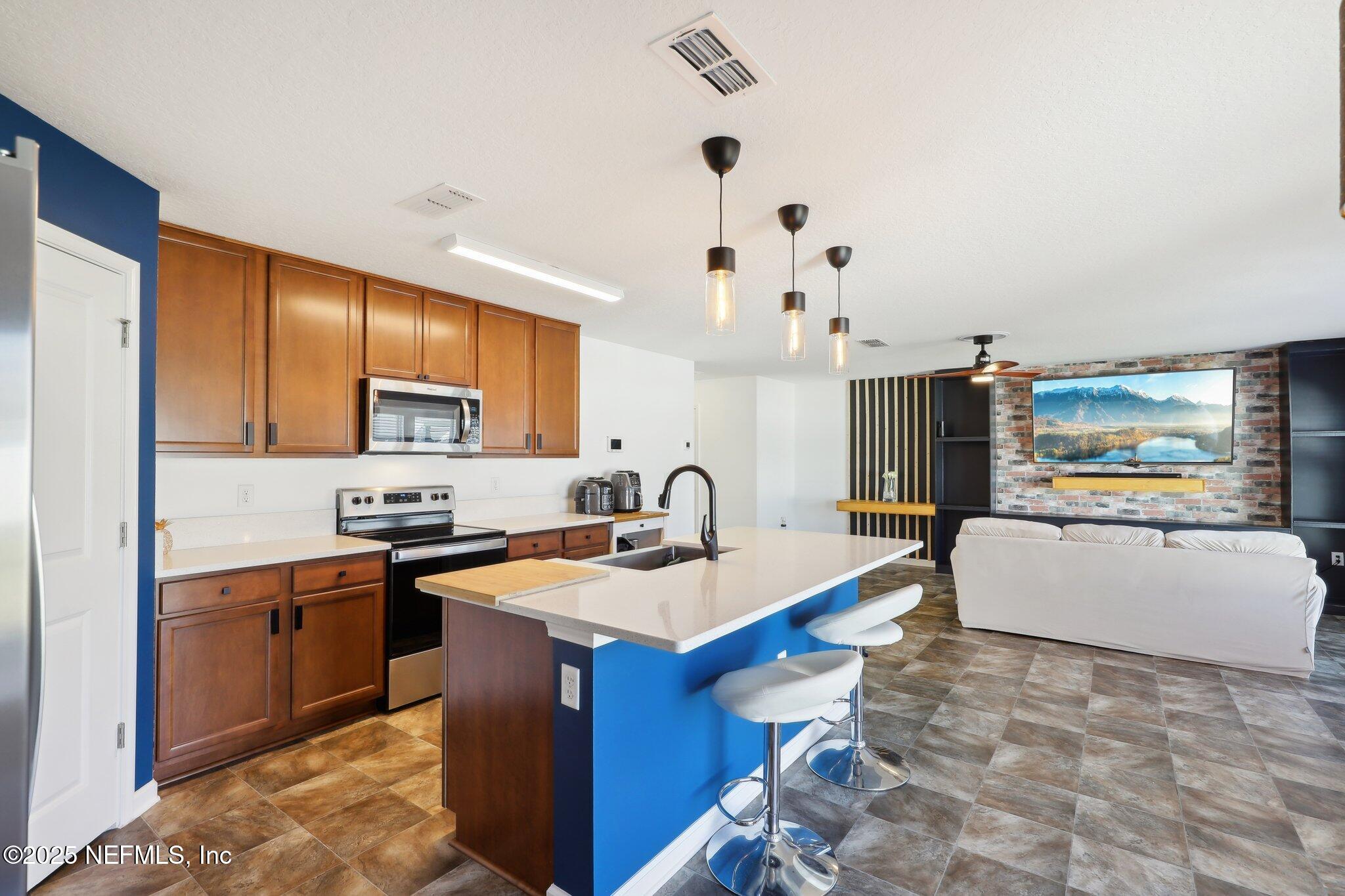 11461 Nathaniel Gorham Way Jacksonville, FL 32221 - Photo 16 of 42 a kitchen with stainless steel appliances granite countertop a sink a stove and a refrigerator