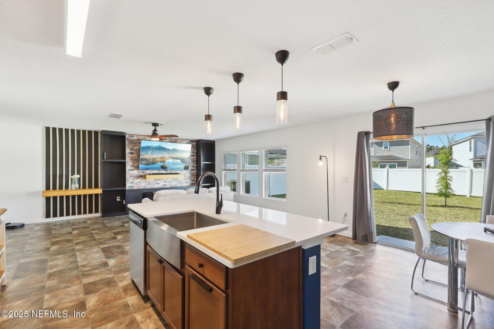 11461 Nathaniel Gorham Way Jacksonville, FL 32221 - Photo 17 of 42 a kitchen with a stove a refrigerator a sink dishwasher with a dining table and chairs with wooden floor