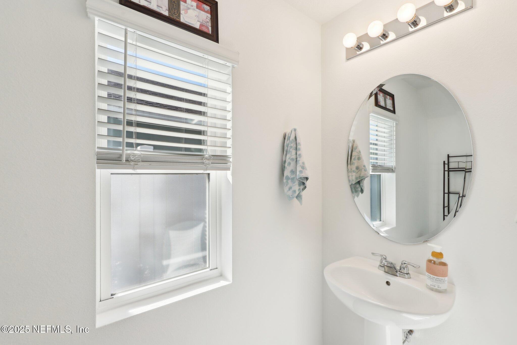 11461 Nathaniel Gorham Way Jacksonville, FL 32221 - Photo 18 of 42 a bathroom with a sink a mirror and a shower