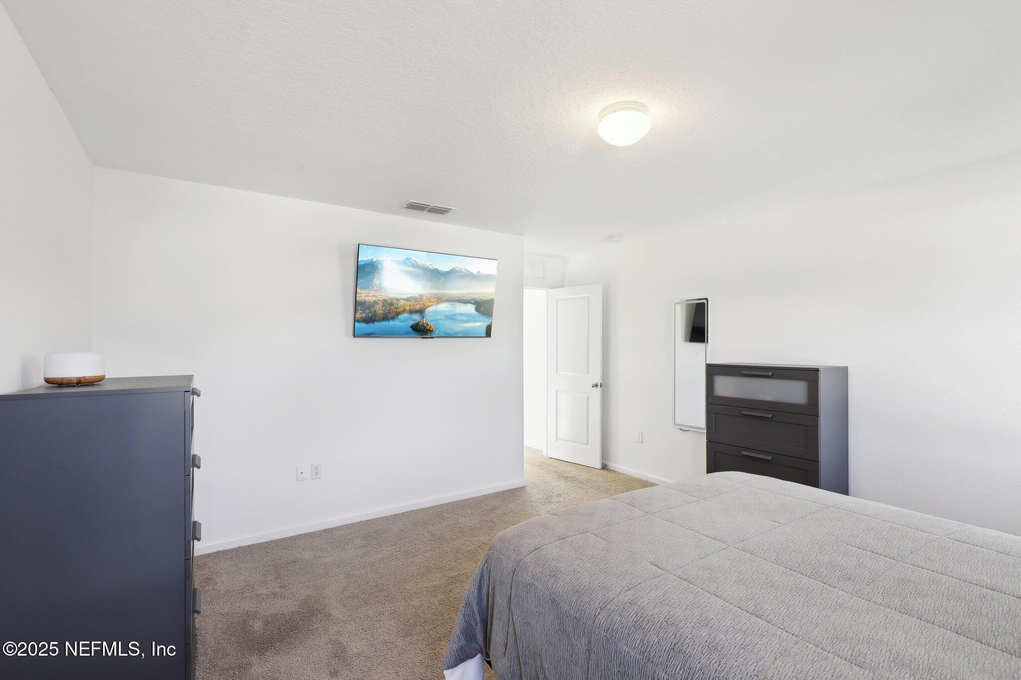 11461 Nathaniel Gorham Way Jacksonville, FL 32221 - Photo 30 of 42 a bedroom with a bed and a painting on the wall