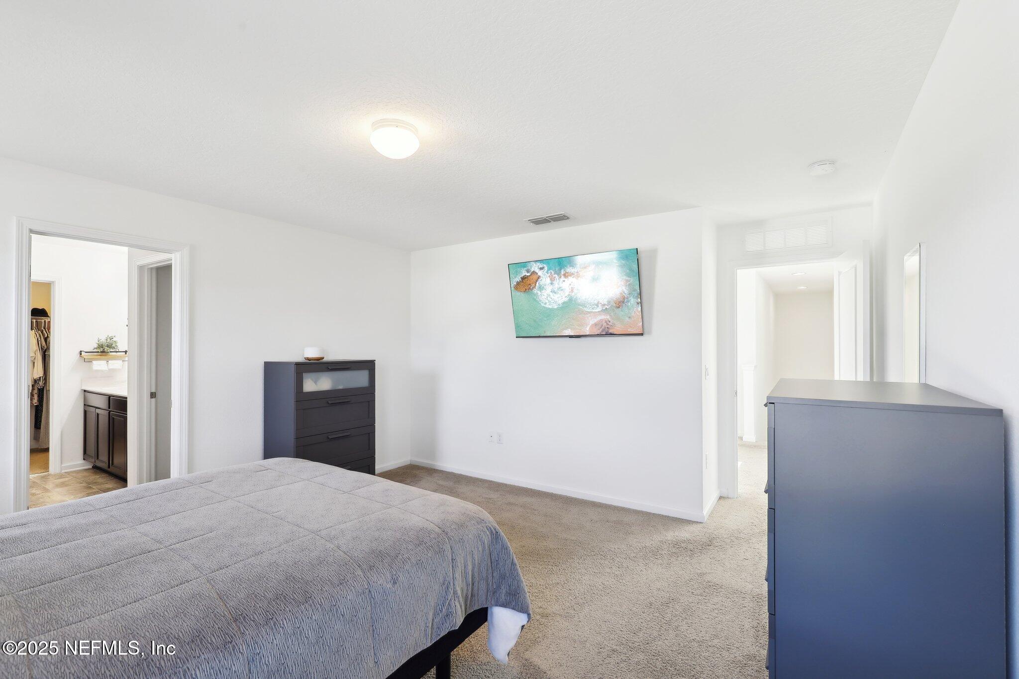 11461 Nathaniel Gorham Way Jacksonville, FL 32221 - Photo 31 of 42 a bedroom with a bed and a painting on the wall