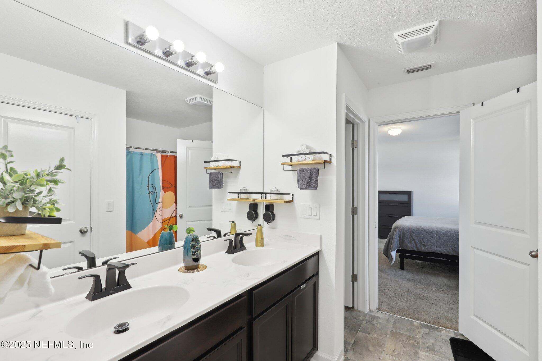 11461 Nathaniel Gorham Way Jacksonville, FL 32221 - Photo 33 of 42 a en suite bathroom with a sink double vanity and a mirror