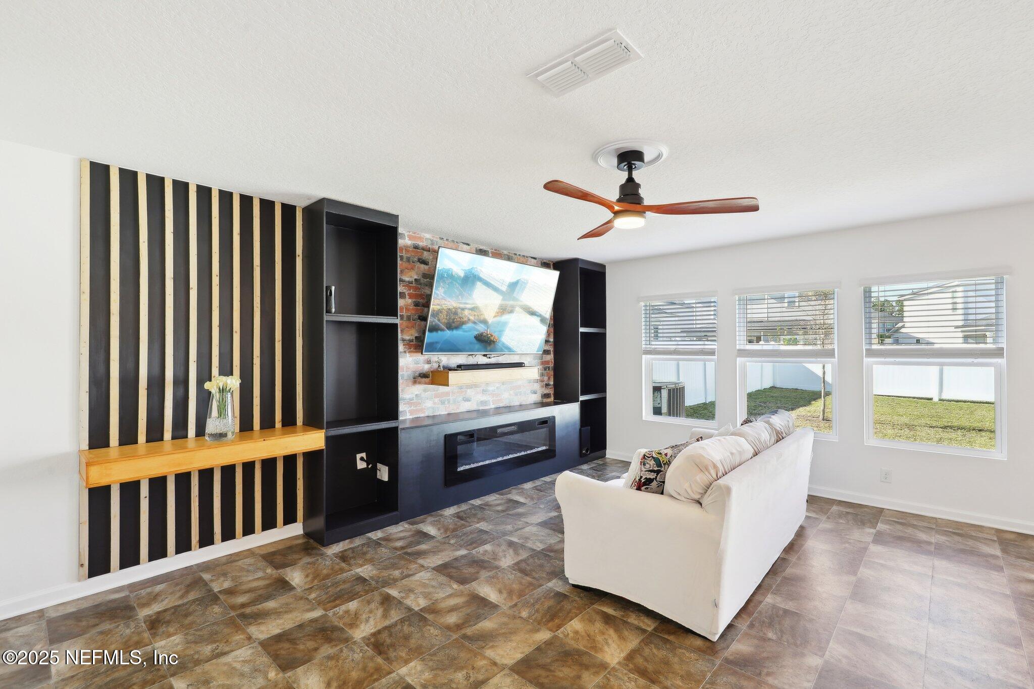 11461 Nathaniel Gorham Way Jacksonville, FL 32221 - Photo 10 of 42 a living room with furniture and a flat screen tv