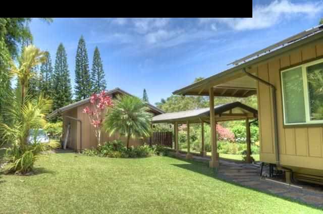1629 West Kuiaha Road Haiku, HI 96708 - Photo 3 of 29 a backyard of a house with table and chairs under an umbrella