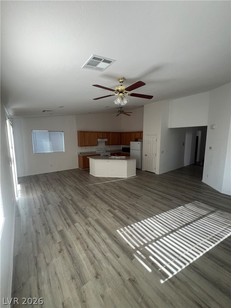6472 Centennial Road Pahrump, NV 89048 - Photo 33 of 33 An open floorplan seamlessly connects the living area with a functional kitchen island, illuminated by overhead lighting.