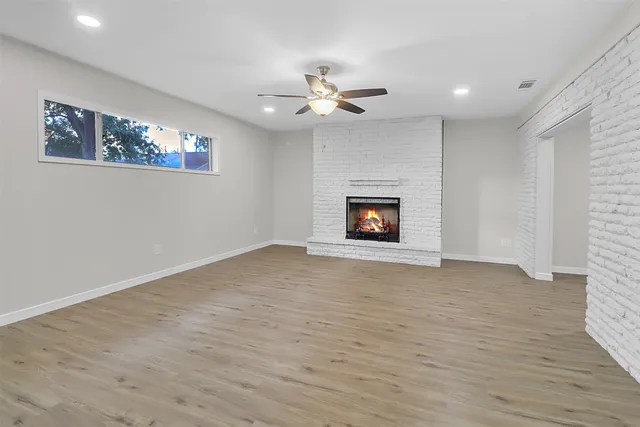 a view of an empty room with a fireplace and a window