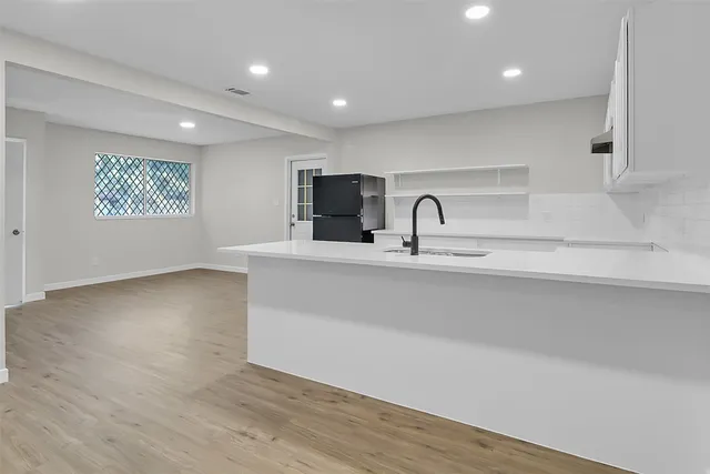 a kitchen with kitchen island a sink appliances and a counter top space