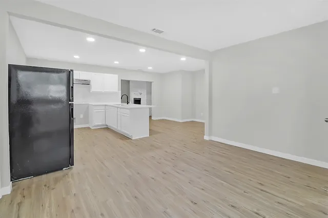 a large kitchen with a wooden floor and stainless steel appliances