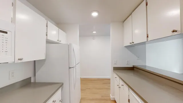 a kitchen with a sink a refrigerator and cabinets