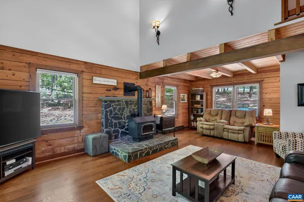 a living room with furniture a flat screen tv and a large window