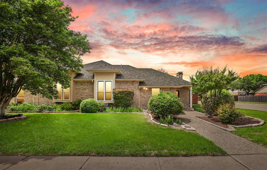 a view of a house with a big yard plants and large trees