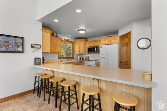1340 Trapper Loop Garden City, UT 84028 - Photo 10 of 35 Kitchen featuring white appliances, a peninsula, light countertops, and recessed lighting